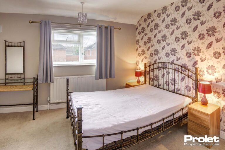 Bedroom with cream carpet and double bed