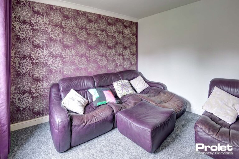 Lounge with purple sofa and purple feature wall