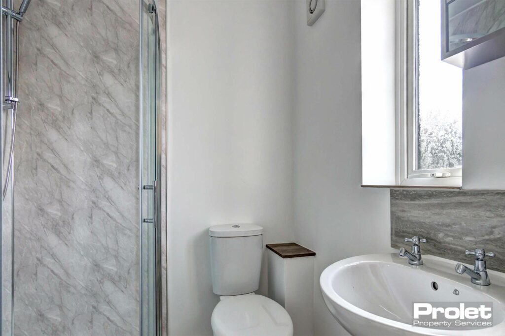 En-suite bathroom with toilet, sink, and shower cubicle