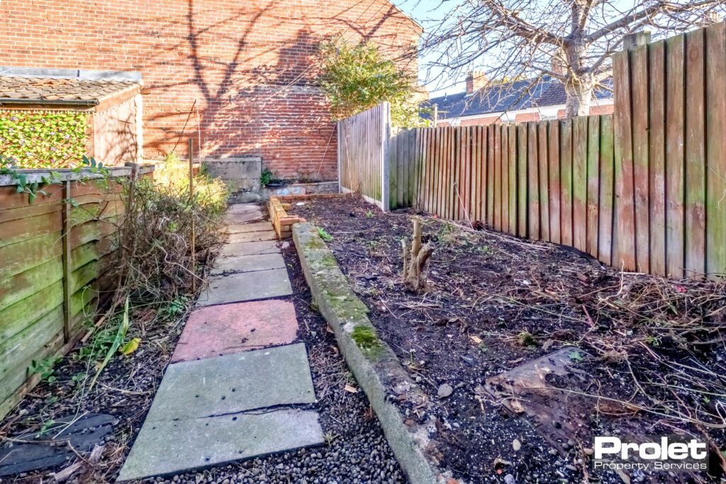 Rear yard with slabs and large raised flower beds
