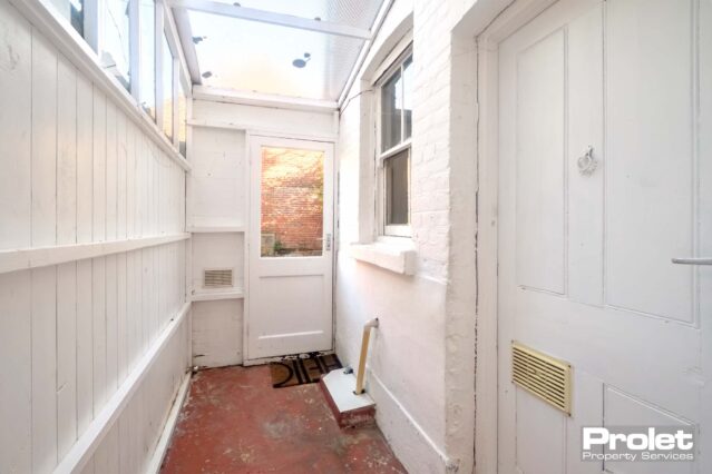 Garden room with white walls and red floor tiles