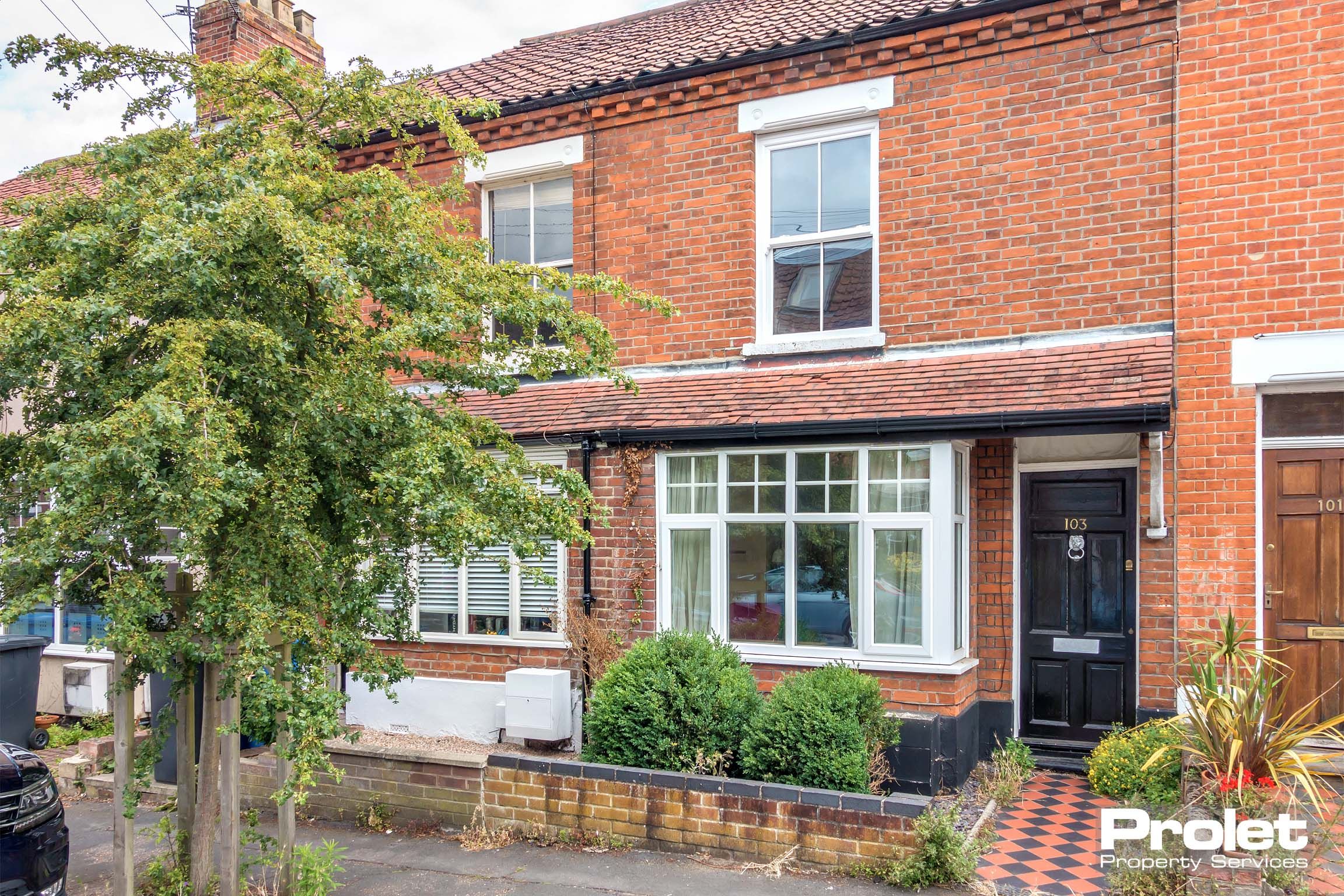 Red brick terraced house with box bay window