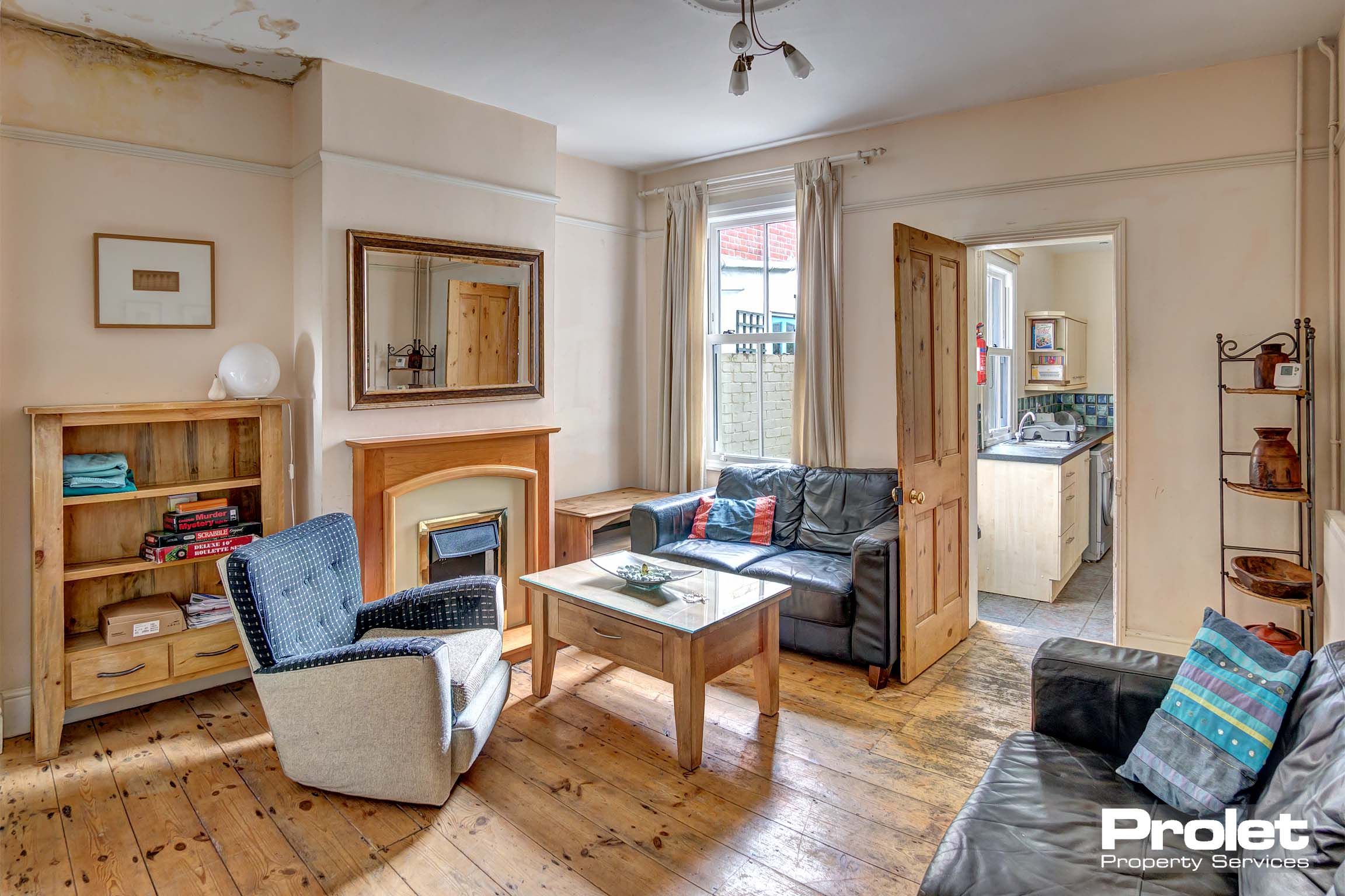 Living room with sofas, hardwood floors, and bookshelf