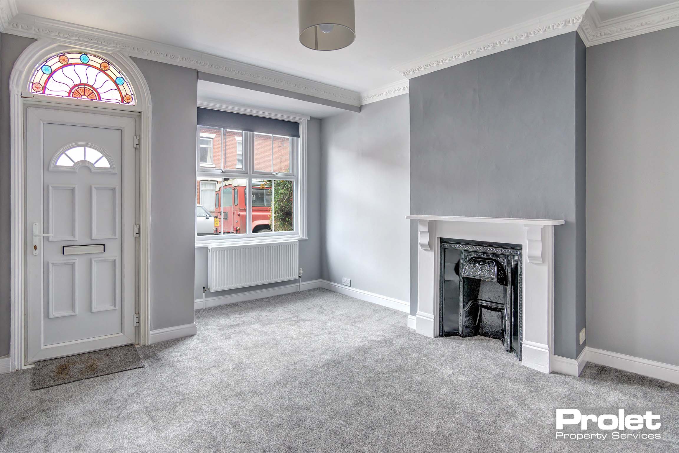 Grey walls and carpet to lounge with feature fireplace