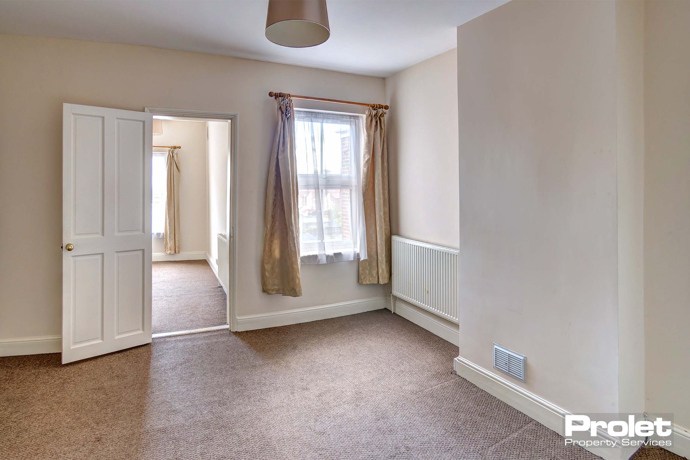 Magnolia walls and brown carpets with neutral shade and curtains