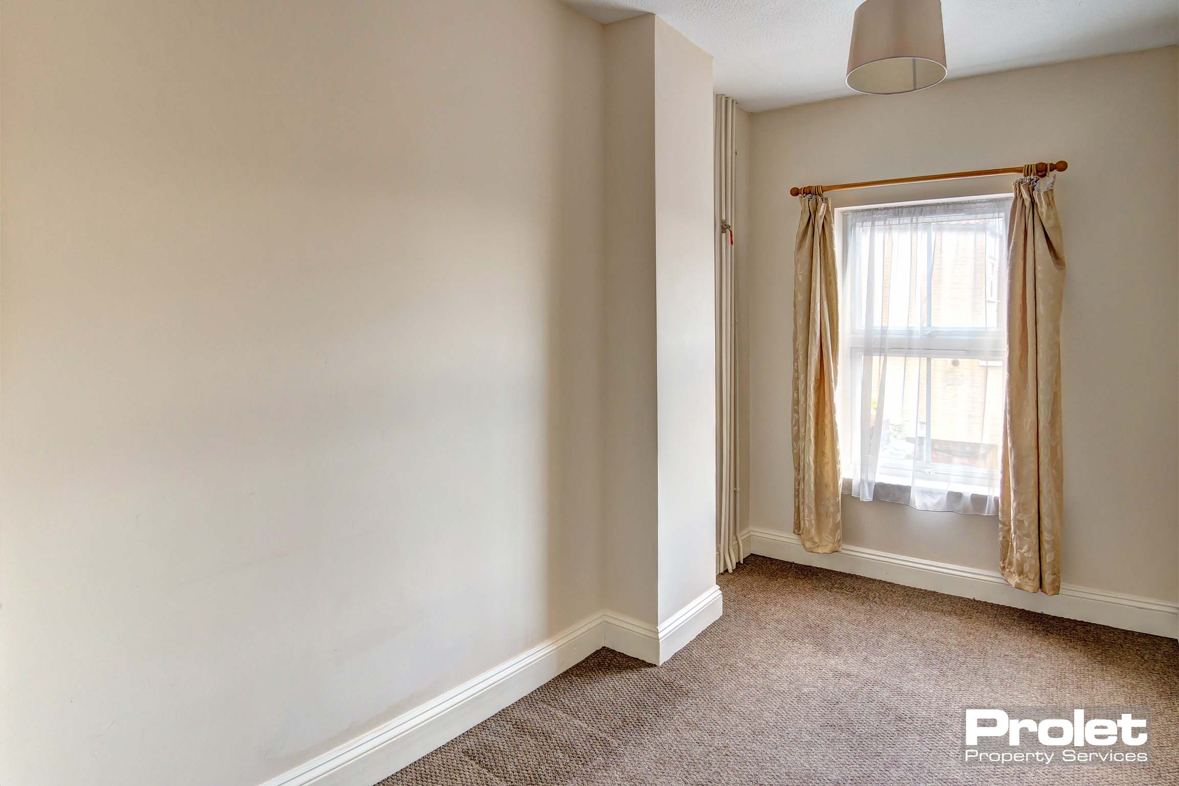 Magnolia walls and brown carpets with neutral shade and curtains