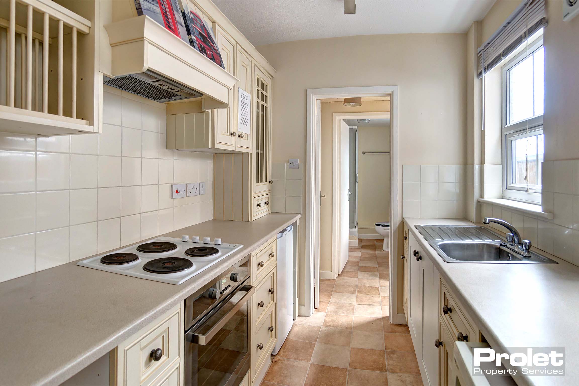 Neutral decor with cream units. Oven, hob, washing machine and fridge freezer