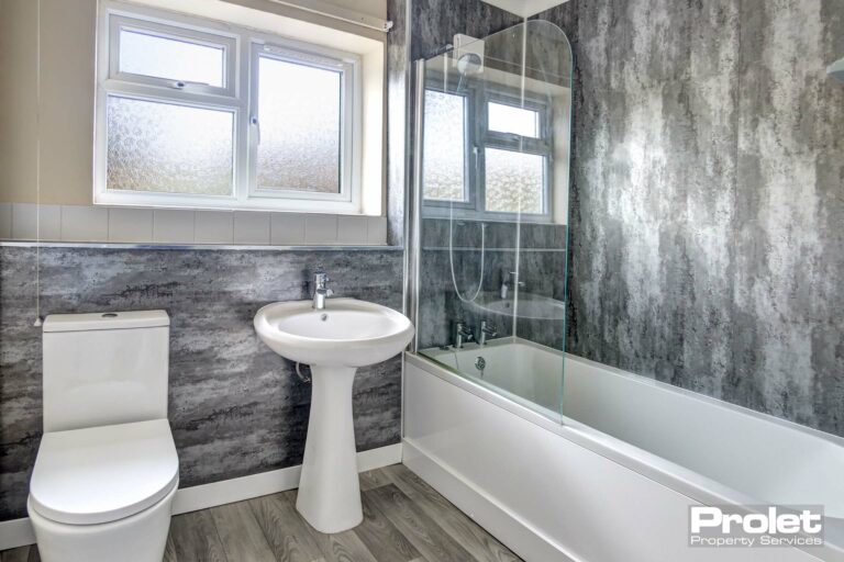 bathroom with grey aqua boarding to walls and white suite