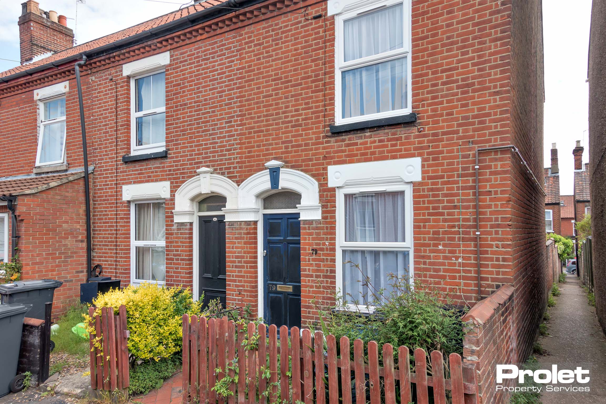 Red brick building with small front garden