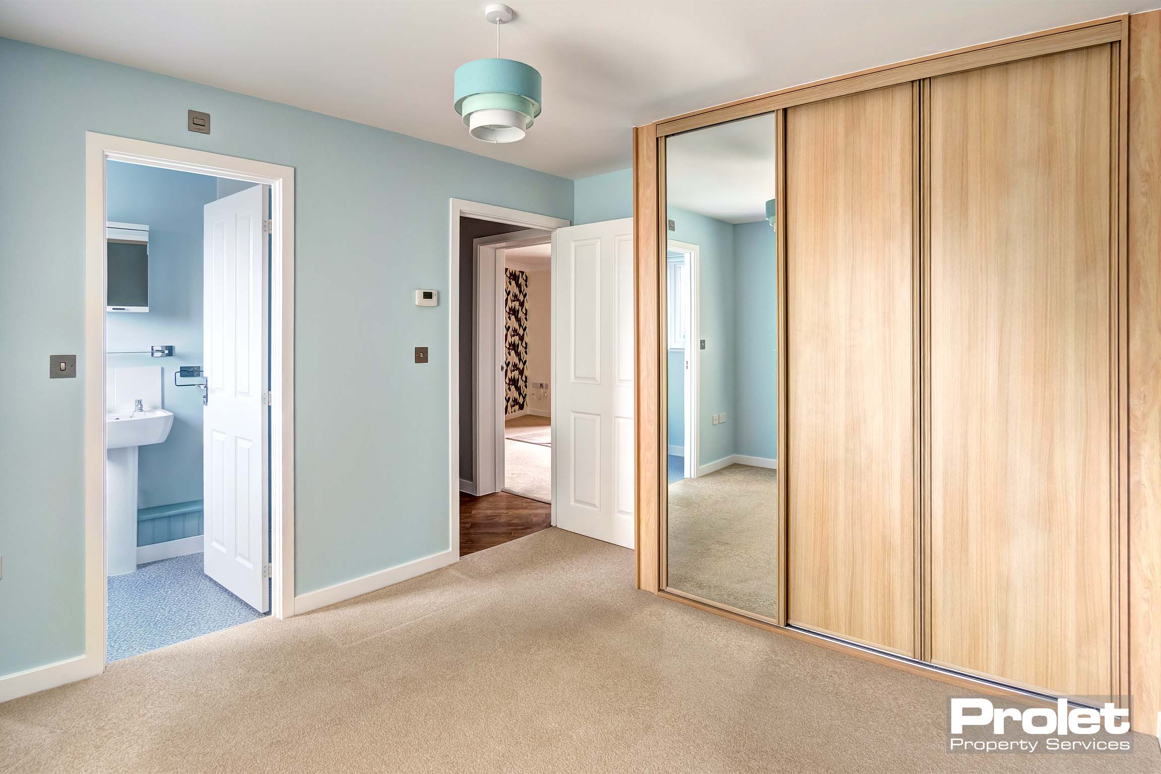 bedroom with fitted wardrobe and duck egg walls