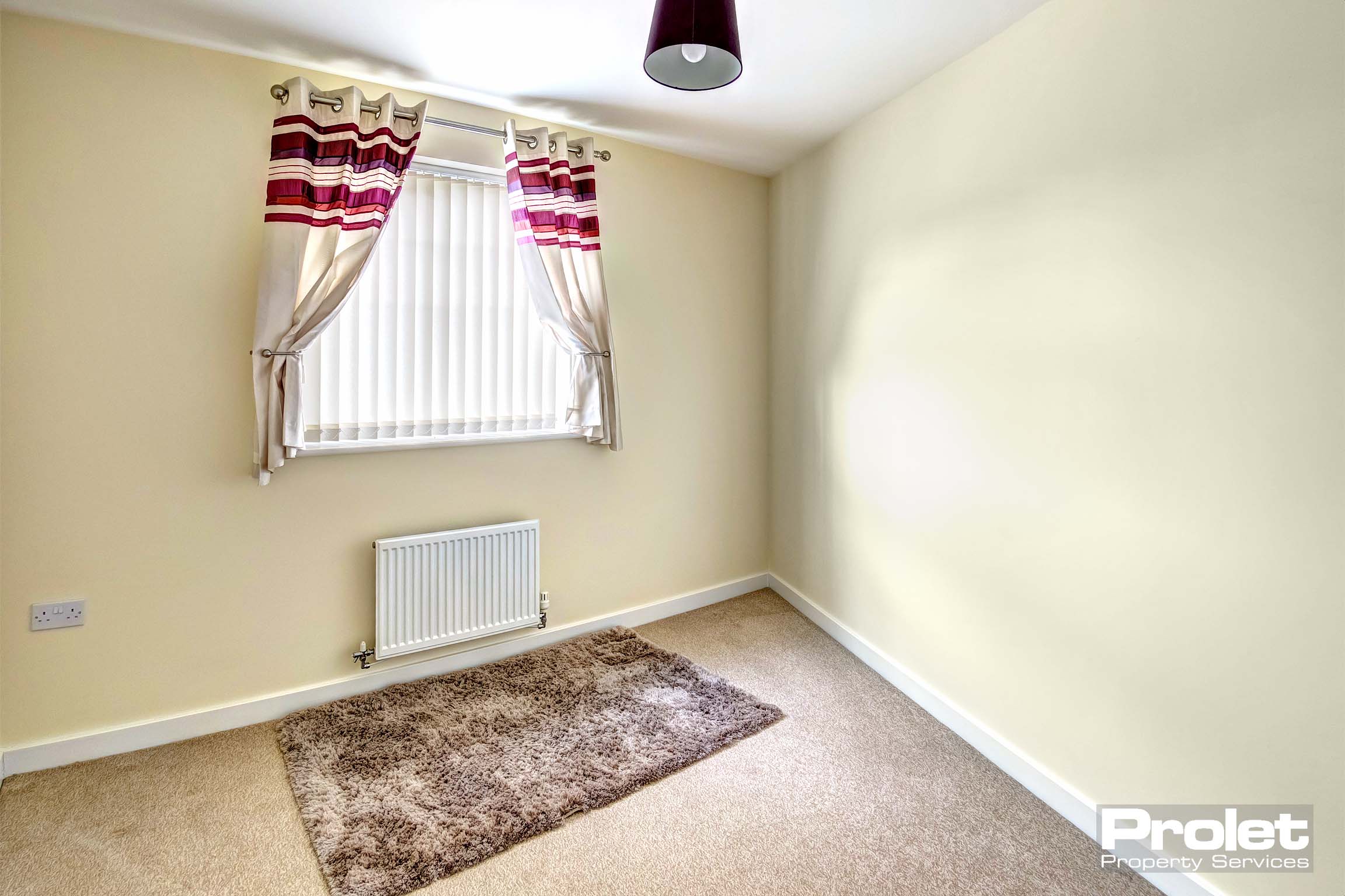 second bedroom with buttercup walls and window with blind and curtains