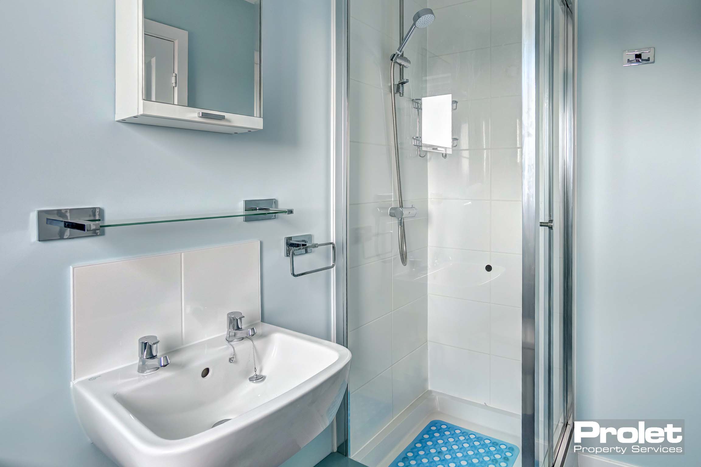 ensuite with white walls, toilet, sink and shower cubicle