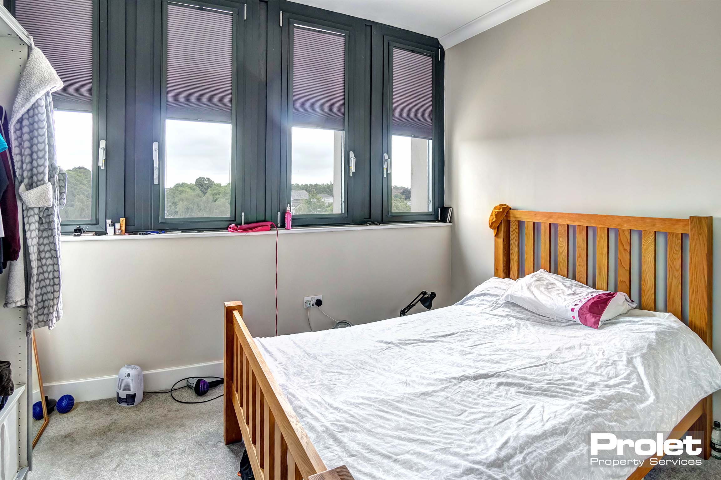 Double bedroom with grey carpet, double bed, and open wardrobe