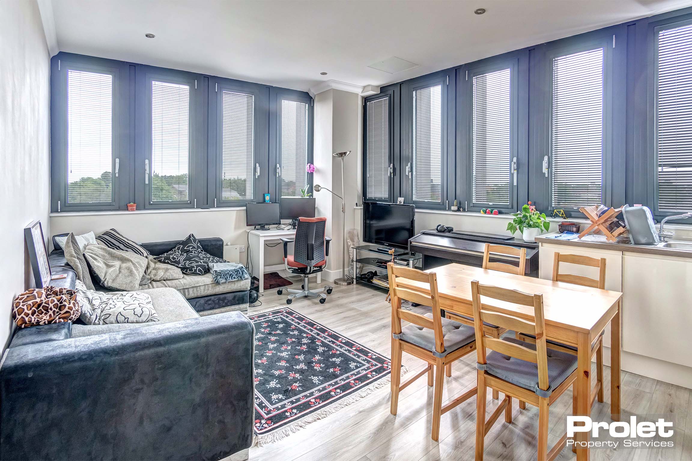 Living/kitchen and dining area with grey laminate flooring.