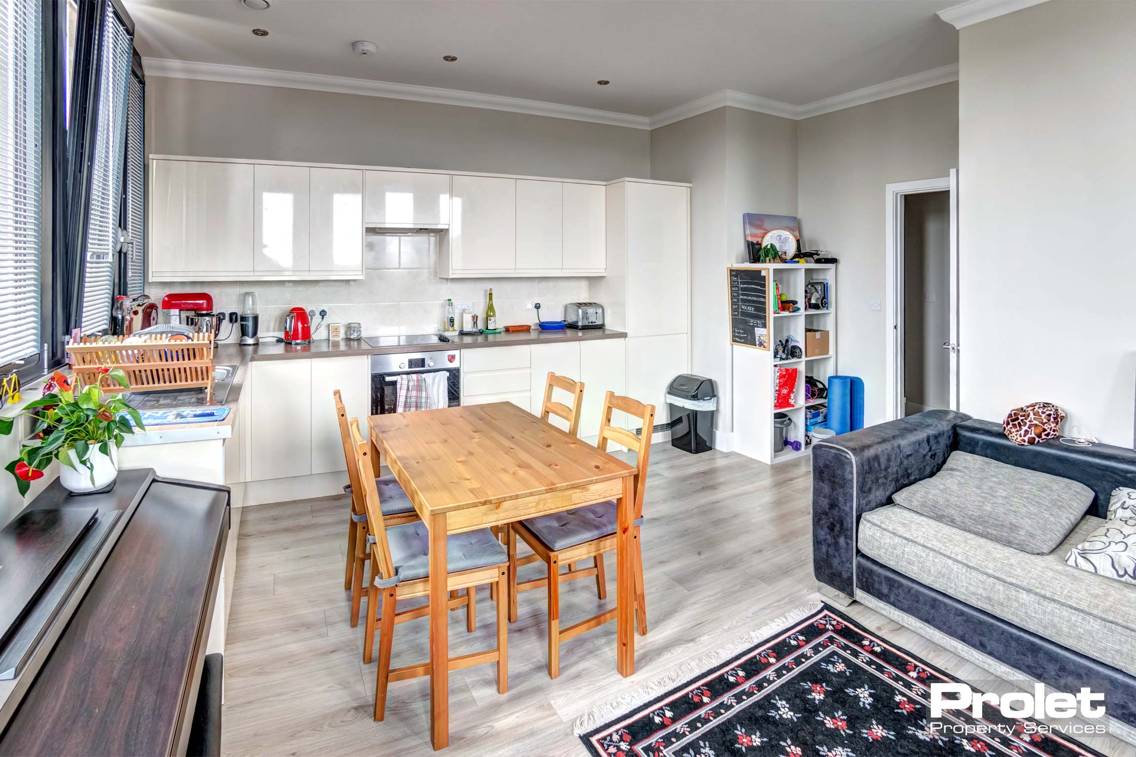 Fitted kitchen with white cabinets and grey worktops