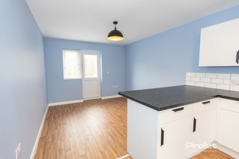 Contemporaty dining area with wood effect flooring and back door leading to garden