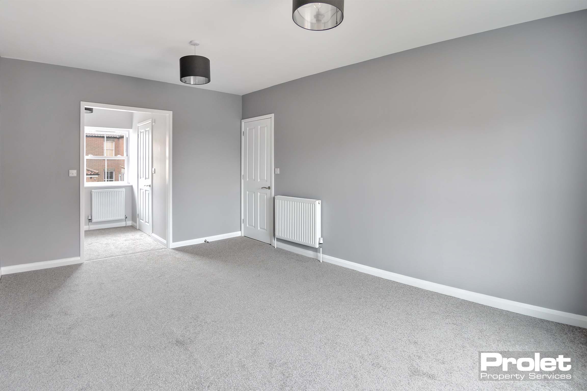 Large double bedroom with grey walls and carpet.