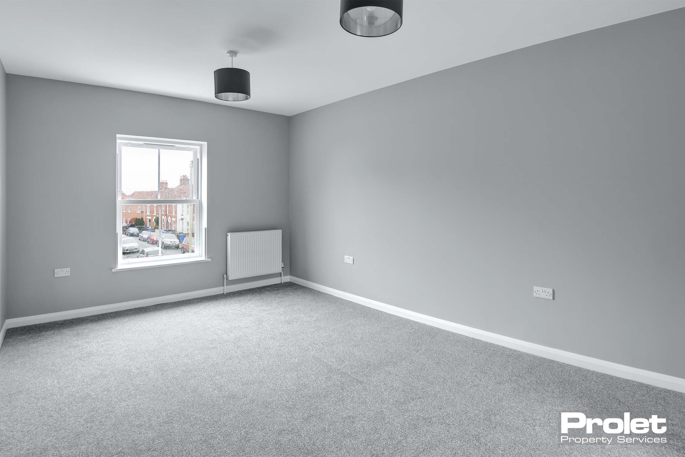 Large double bedroom with grey walls and carpet.