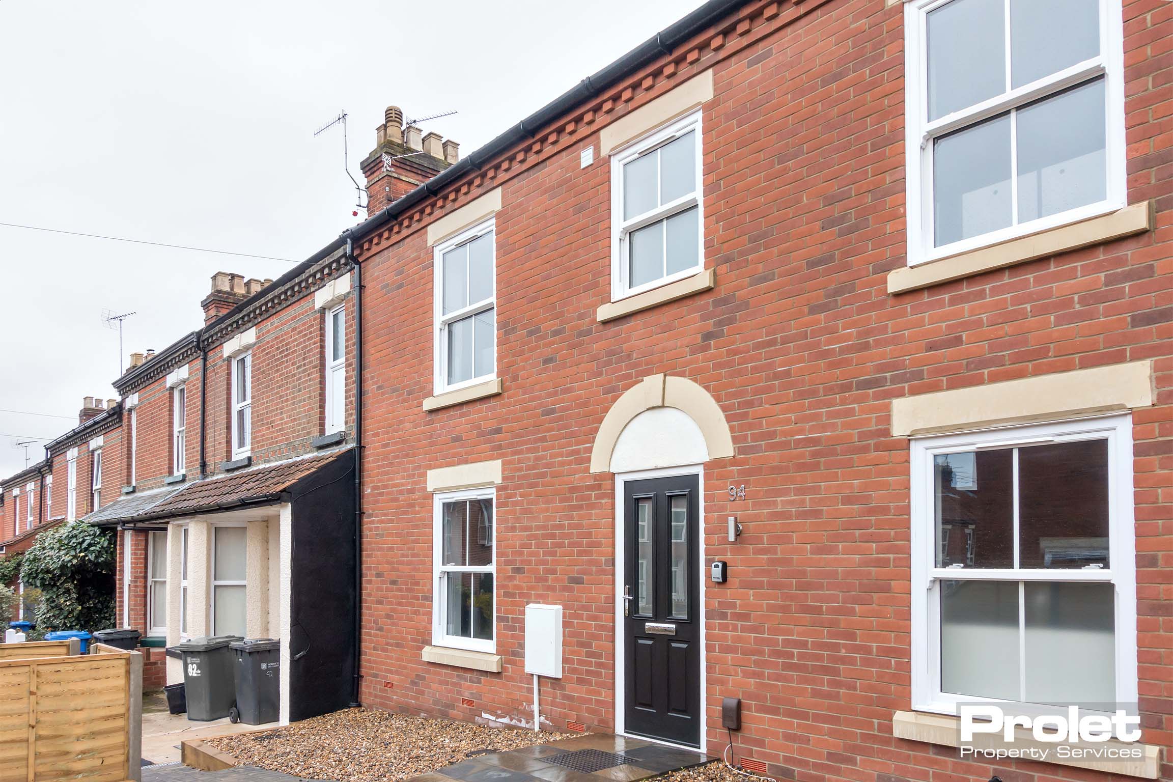 Red brick terraced house with black front door