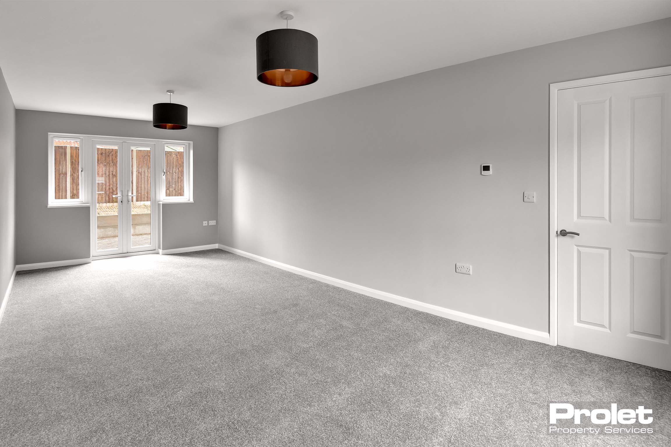Large open lounge with grey walls and carpet.