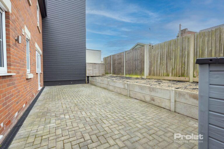 Private back gaden, paved, with raised beds.