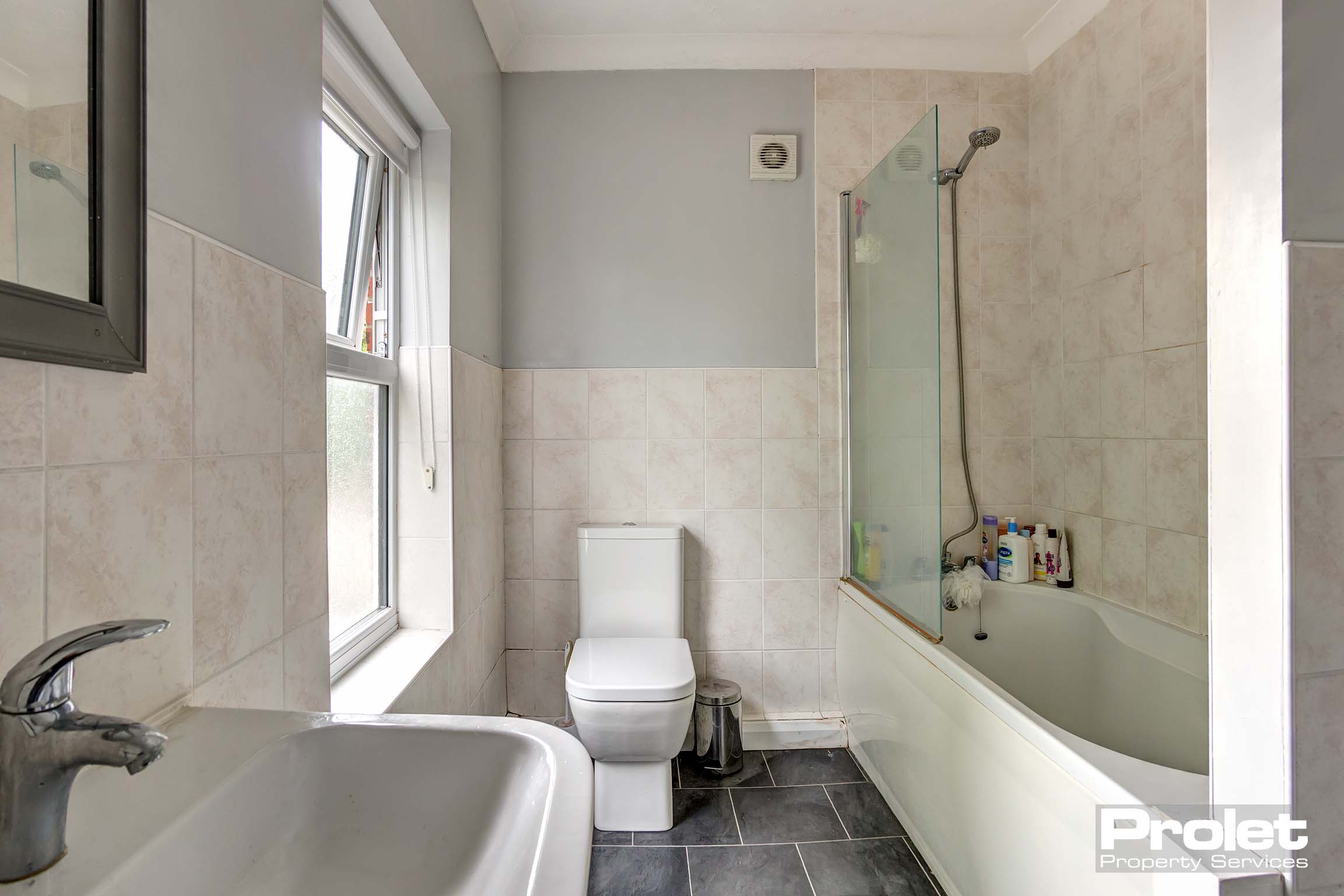 Bathroom with shower over bath, toilet, and sink