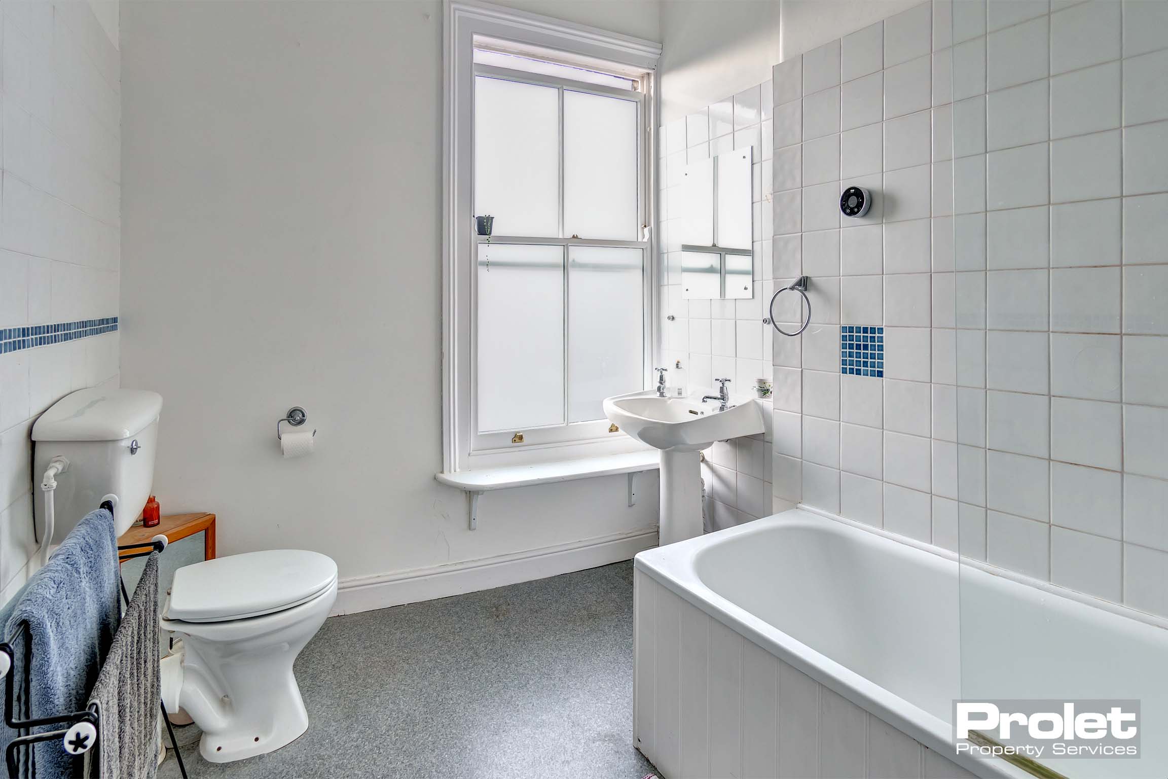 Spacious bathroom with bath, toilet, and sink