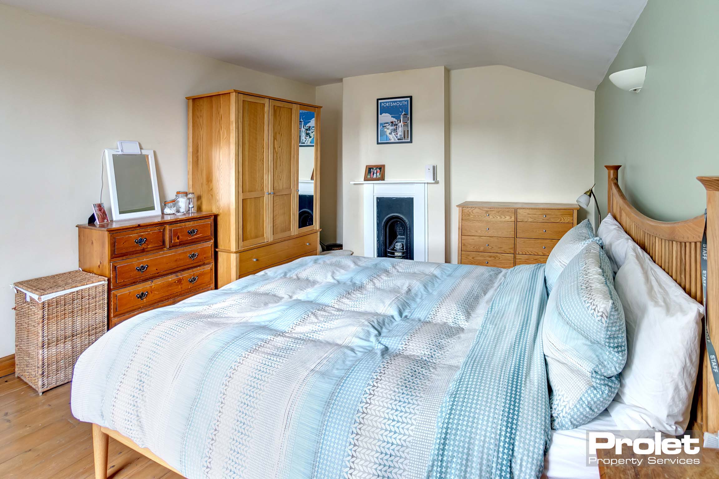 Large double bedroom, with wooden floor and period fireplace.