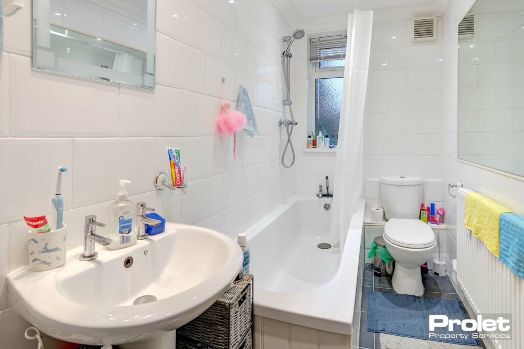 Bathroom with shower over bath, sink, and toilet