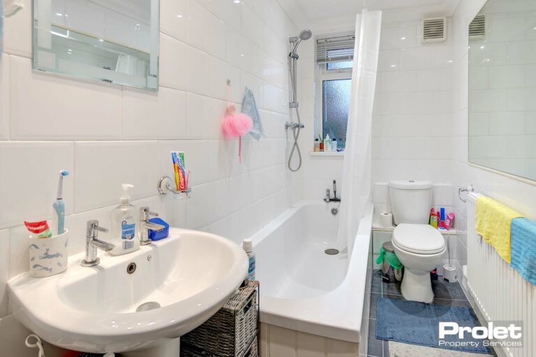 Bathroom with shower over bath, sink, and toilet