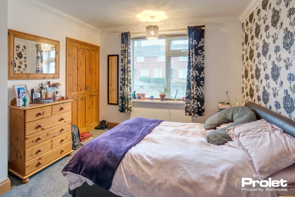 Bedroom with double bed, chest of drawers, and built in wardrobe