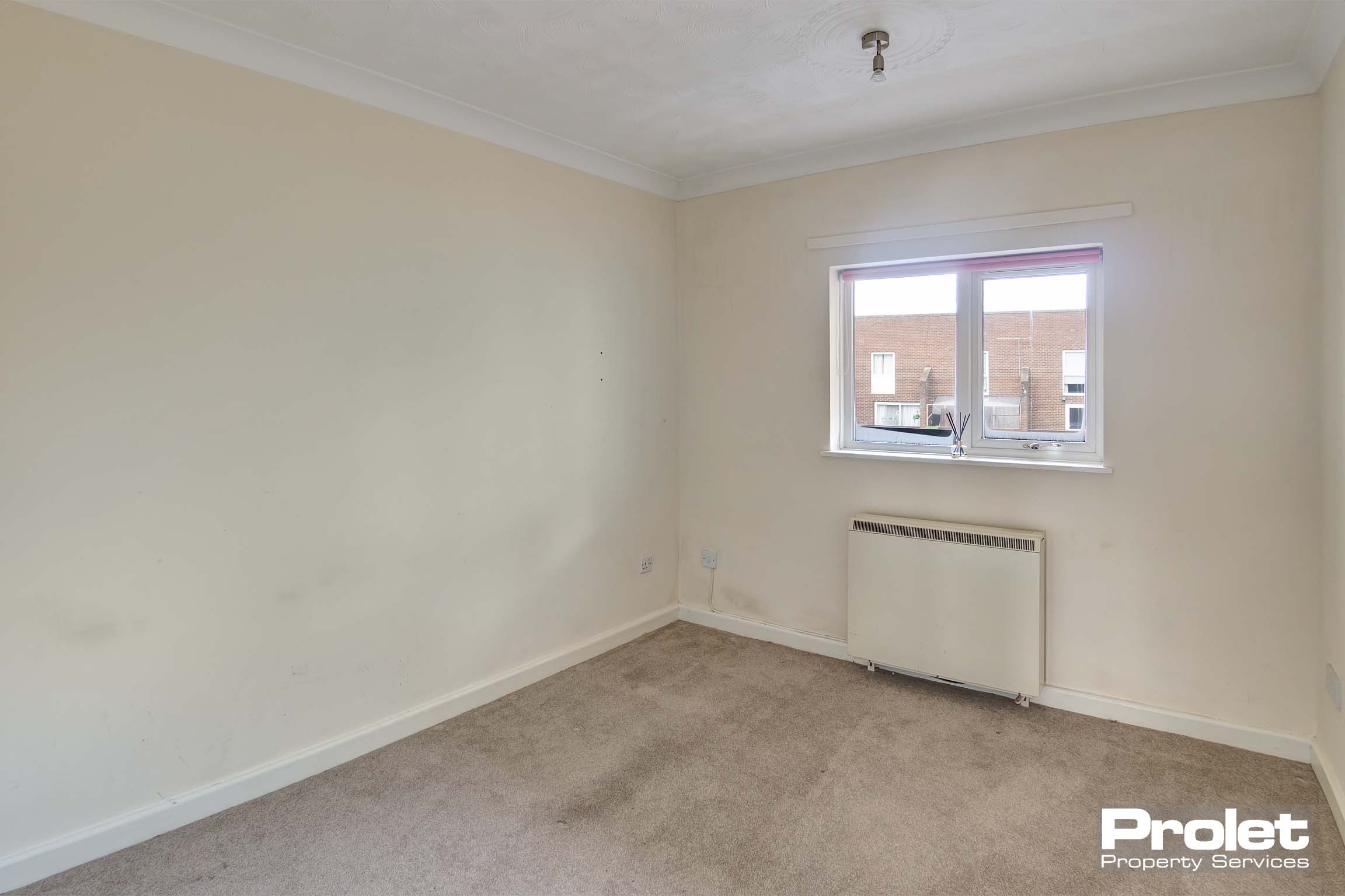 Cream carpets with magnolia walls. Window over looking the front of the building.