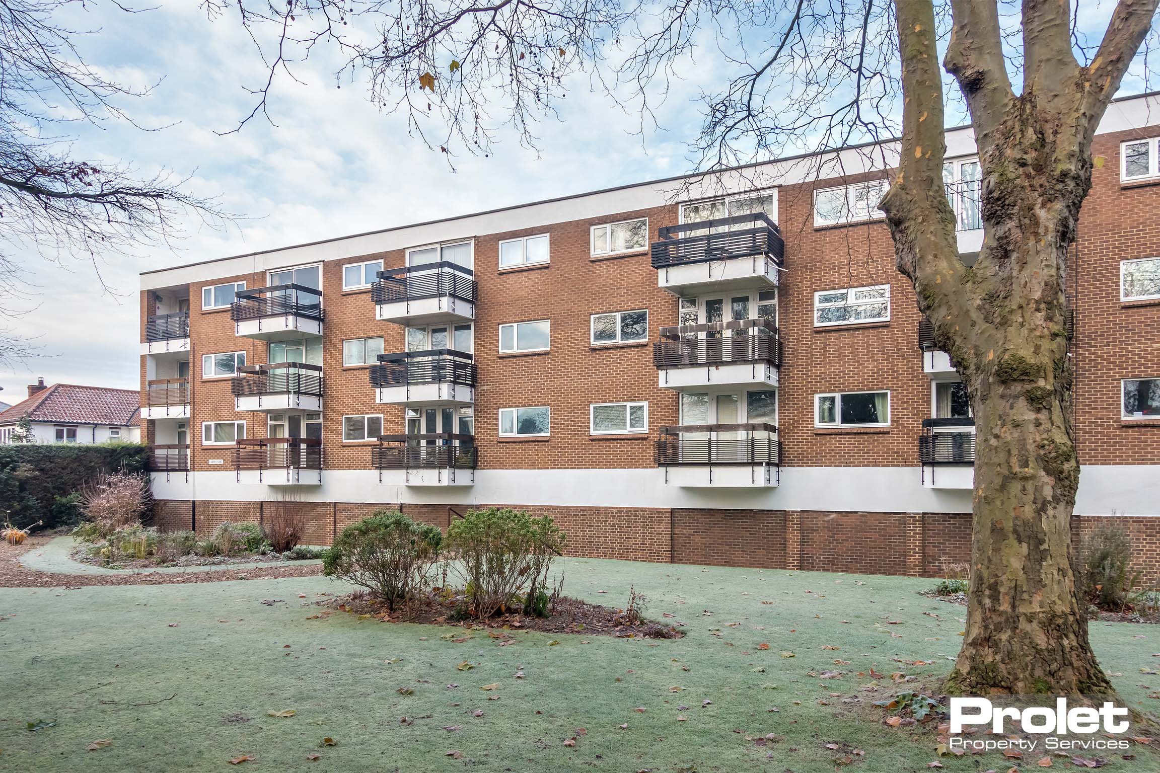 Brick black of flats with balconys and communal garden