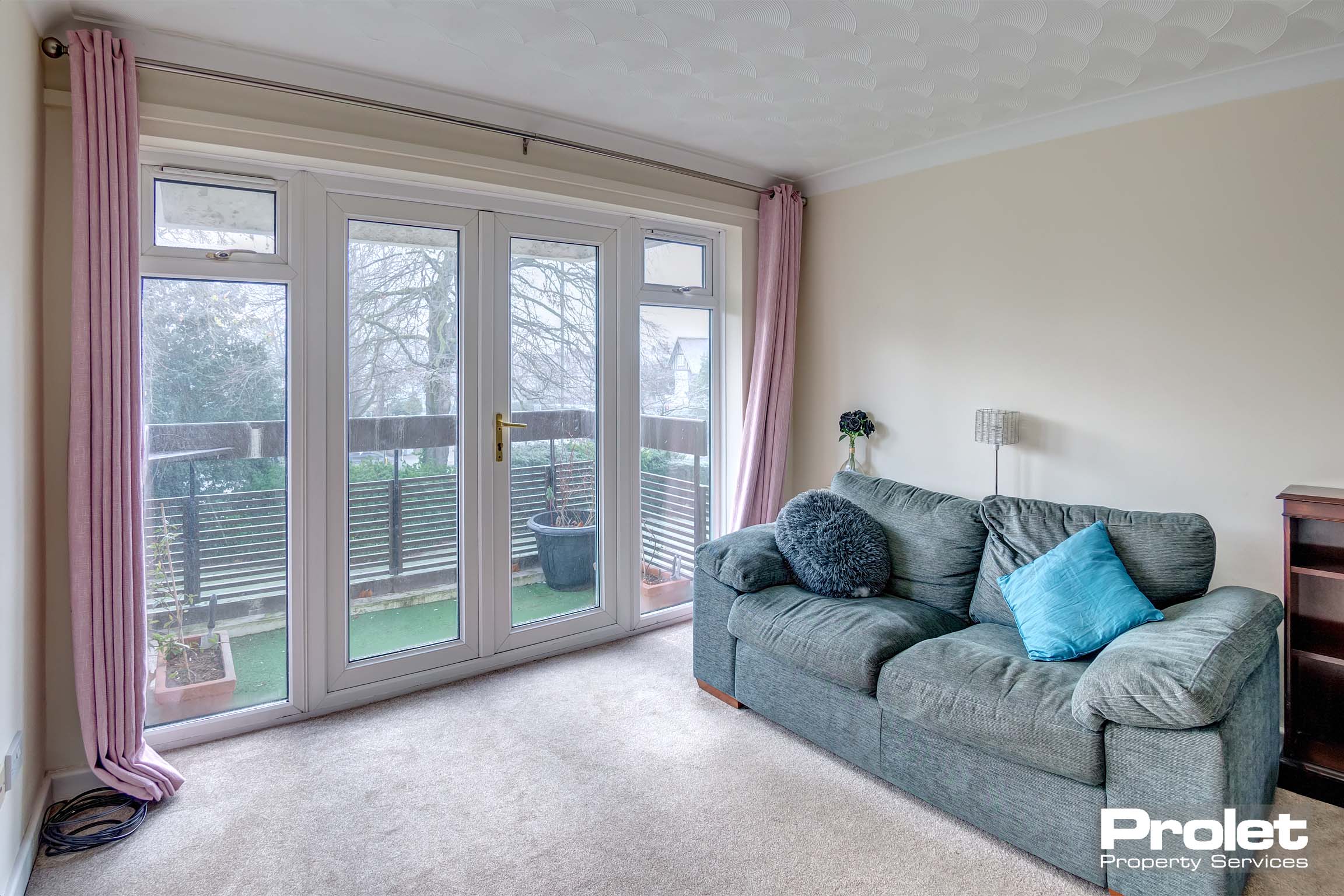 Cream carpets with magnolia walls leading to balcony