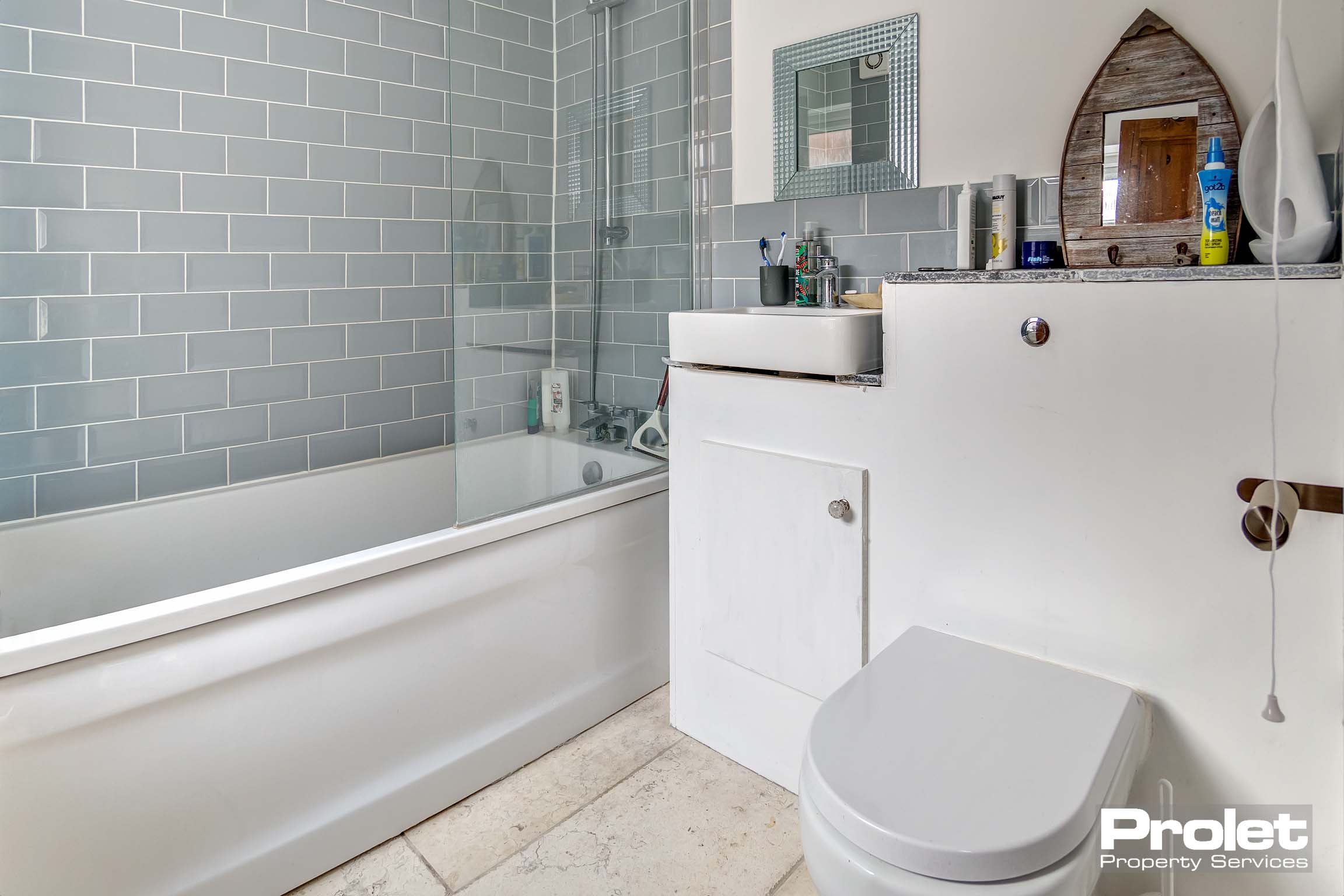 Beige floor, grey tiles and white bathroom suite