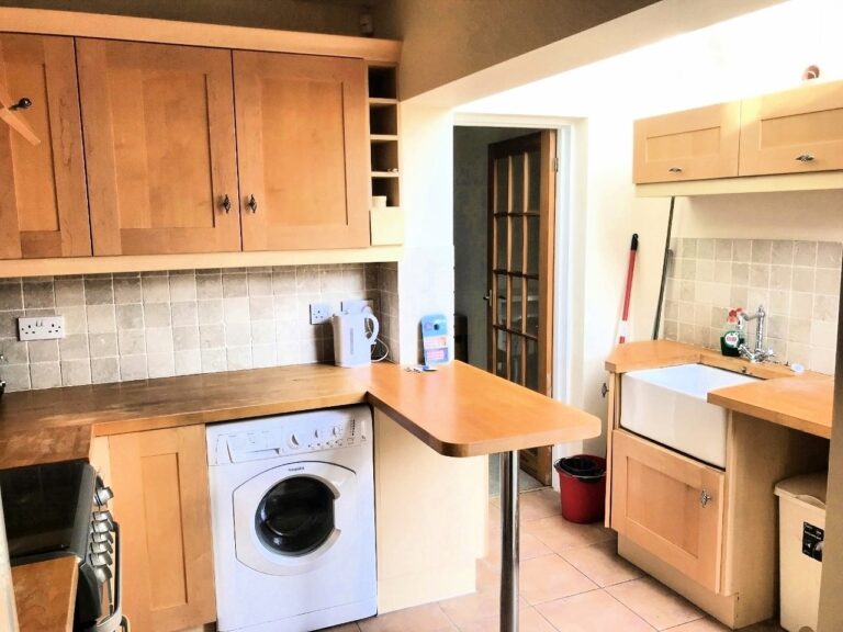 Kitchen with wooden cabinets and worktops, breakfast bar, large appliances and skylight