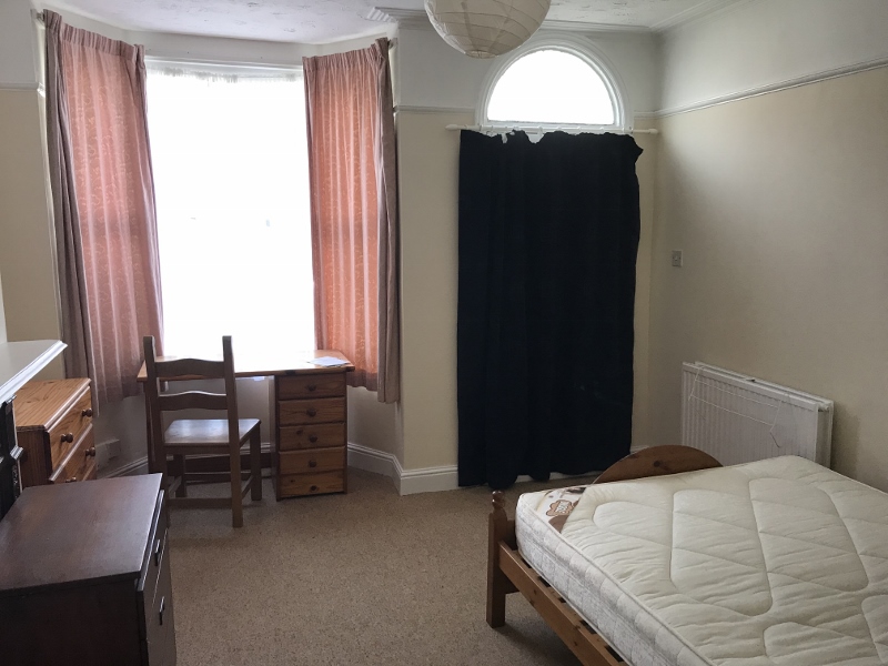 Downstairs bedroom with double bed, desk, and access to front door