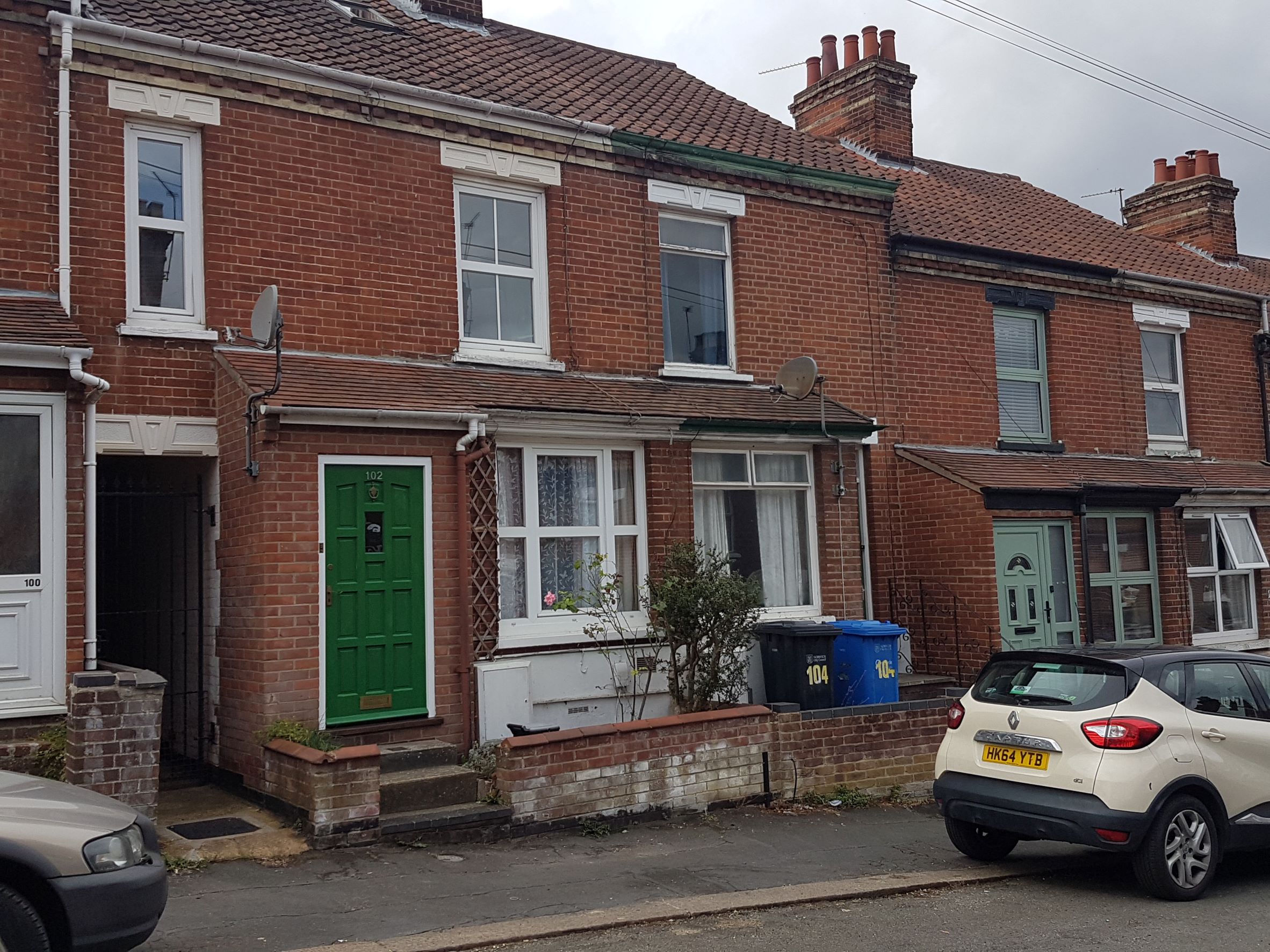 Red brick terraced house with green front door