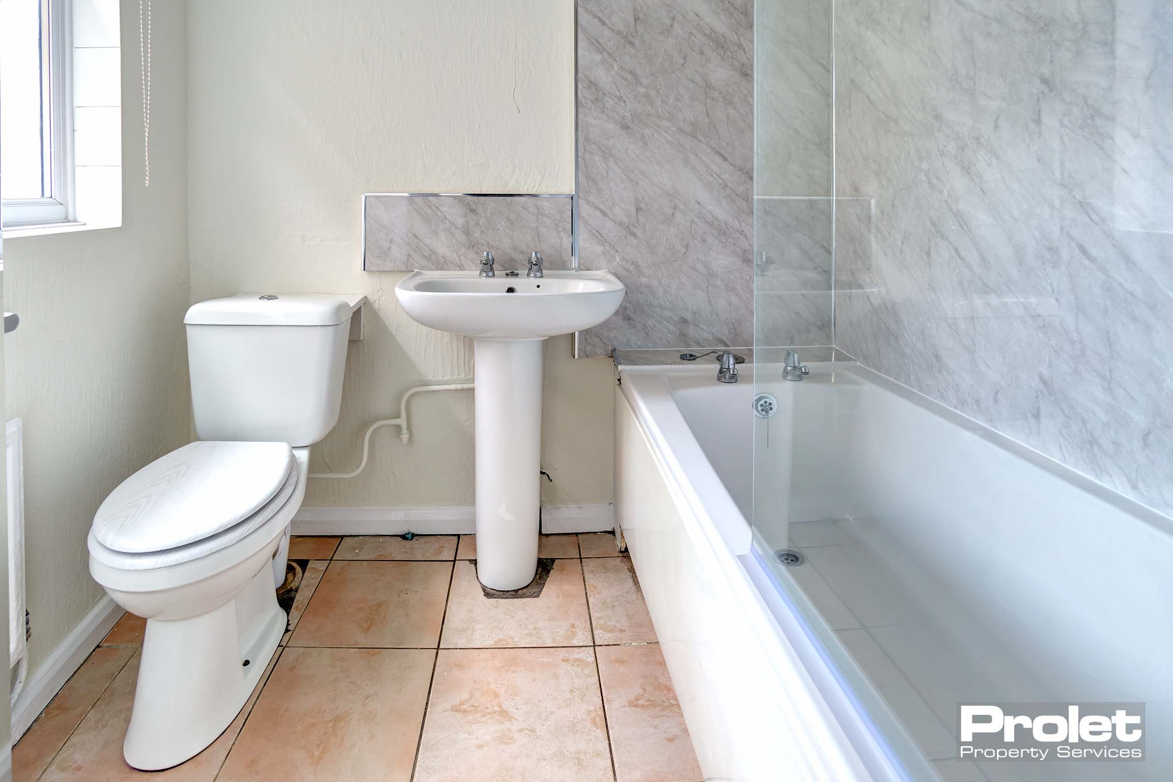 Bathroom with shower over bath, sink, and toilet.