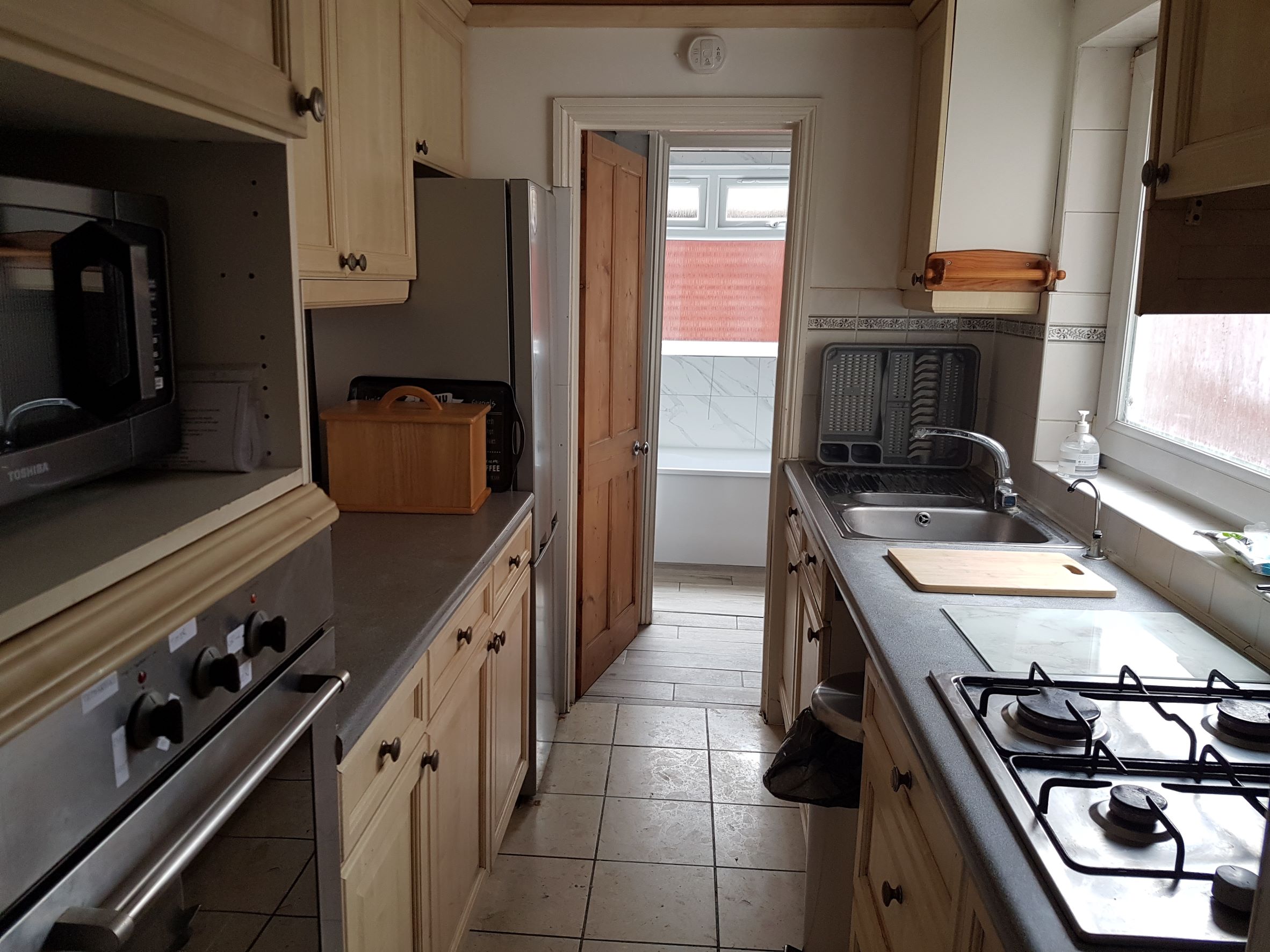 Galley style kitchen with wooden fitted units.
