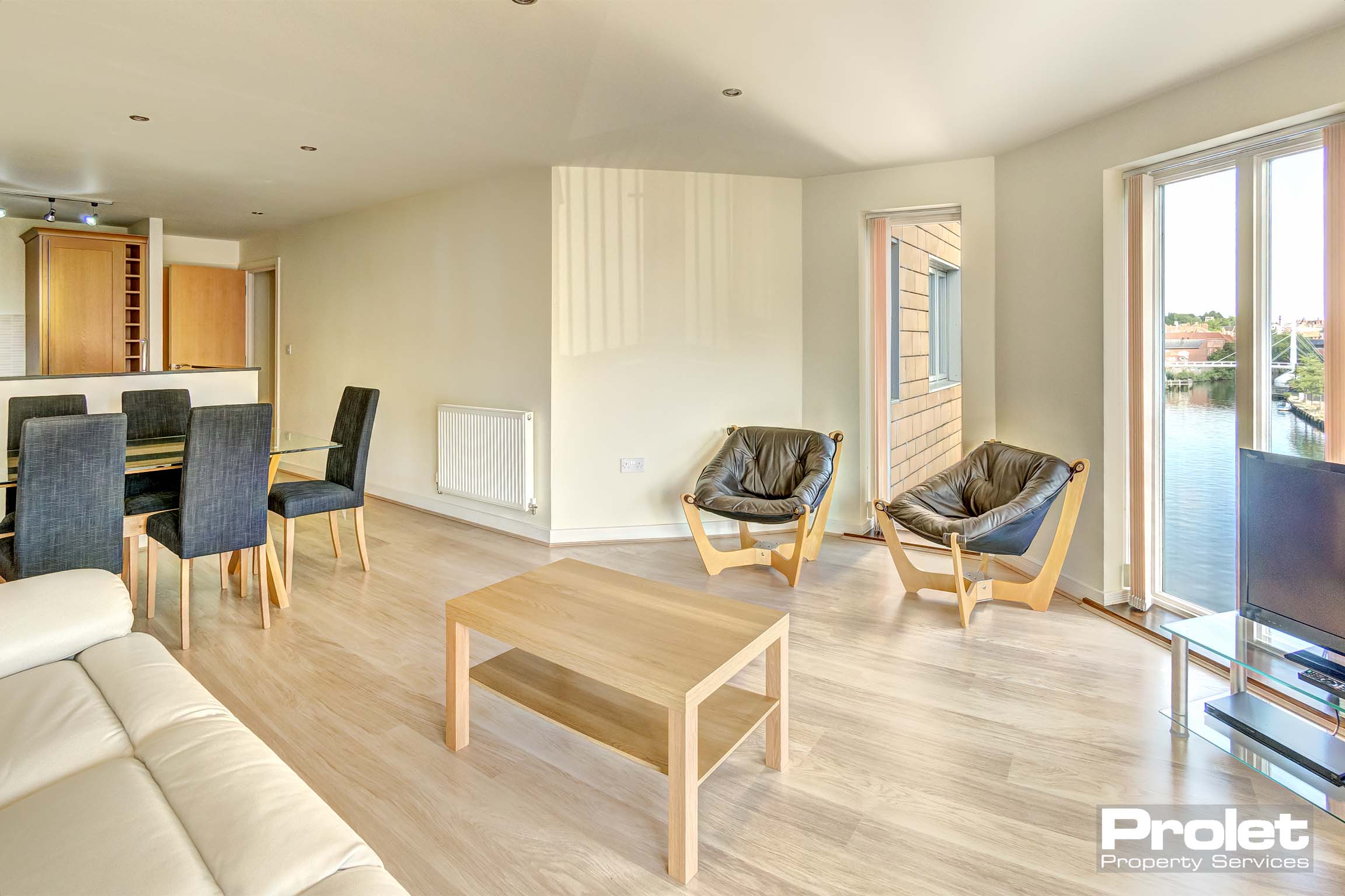 Living room with views of the river, as well as a dining table and chairs
