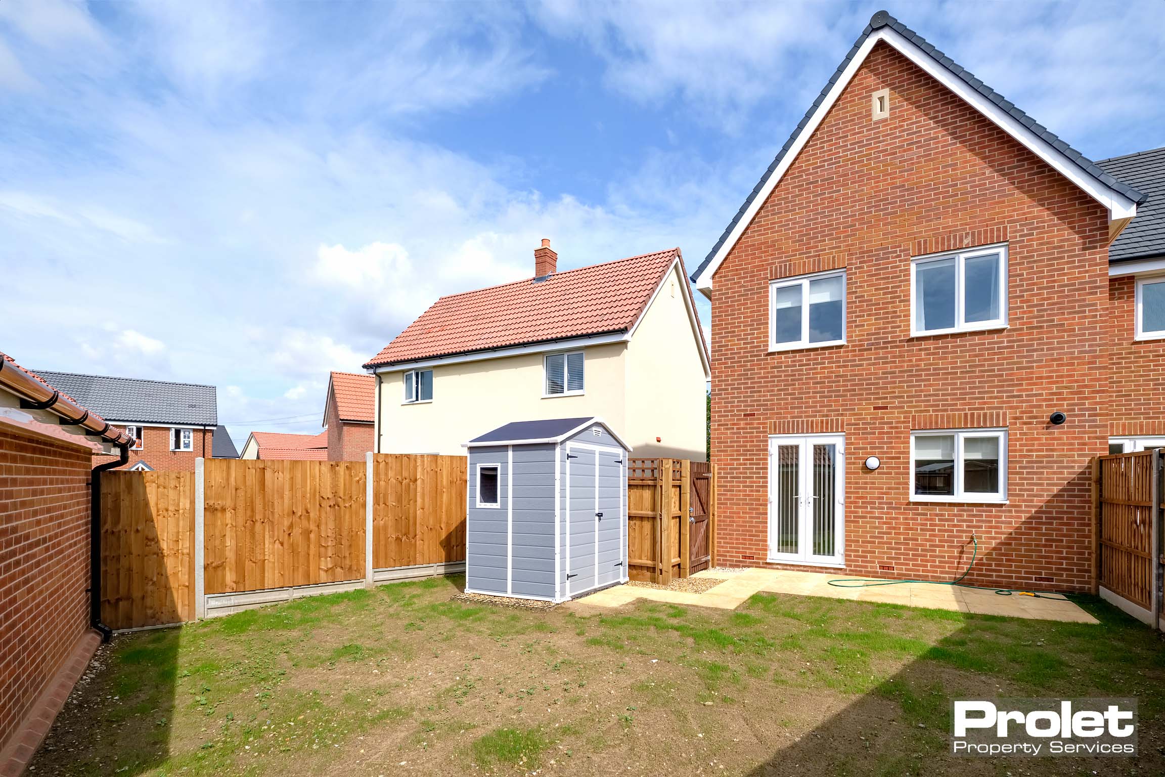 Red brick house with lawn to back garden and small patio area
