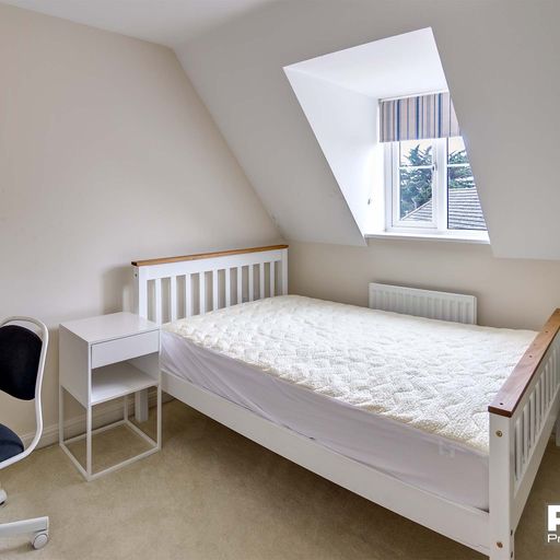 Double bedroom with wooden bedframe and white bedside table
