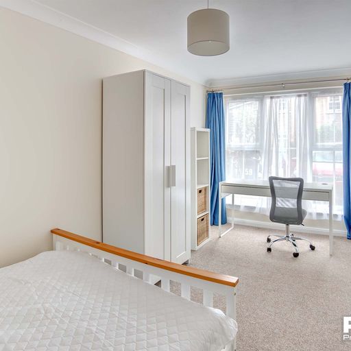 Double bedroom with white desk and wardrobe