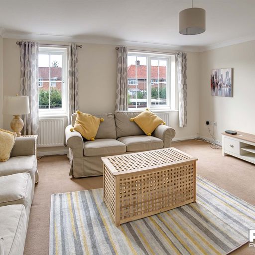 Lounge area with nude coloured fabric sofa and rug