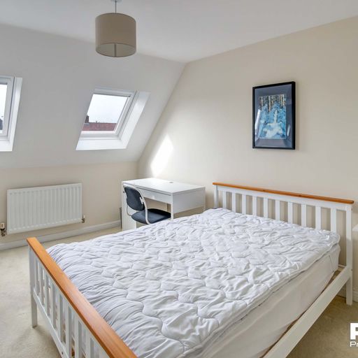 Double bedroom with wooden bed frame and white desk