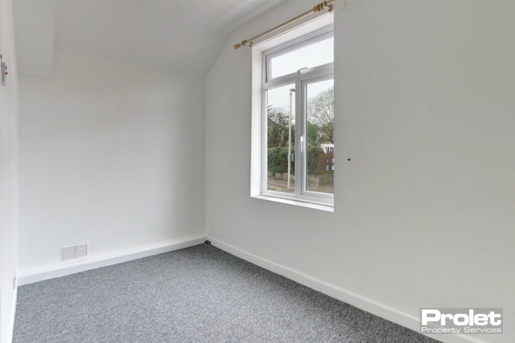 Bedroom with grey carpets and white walls