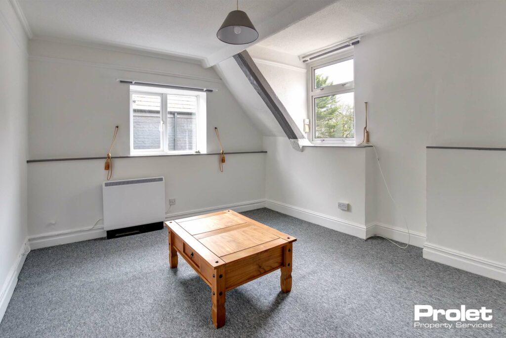 Living room with grey carpet and white walls.