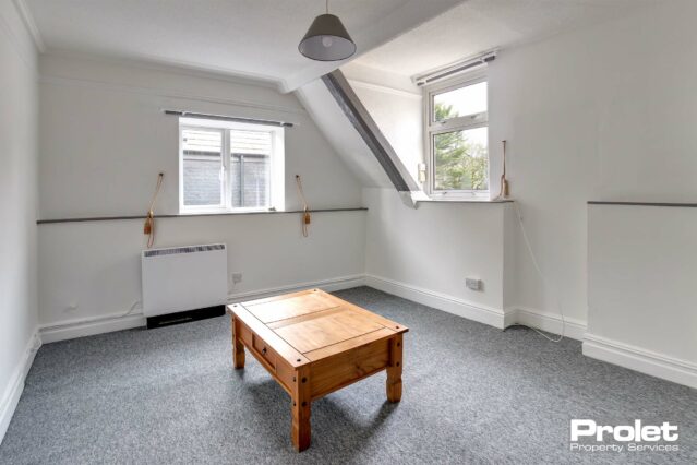 Living room with grey carpet and white walls.