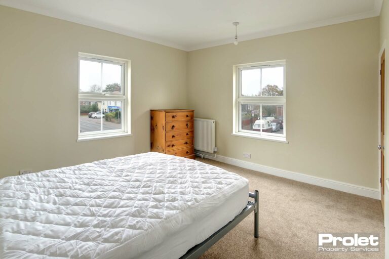 Double bedroom with bed, drawers and built in cupboard with rail